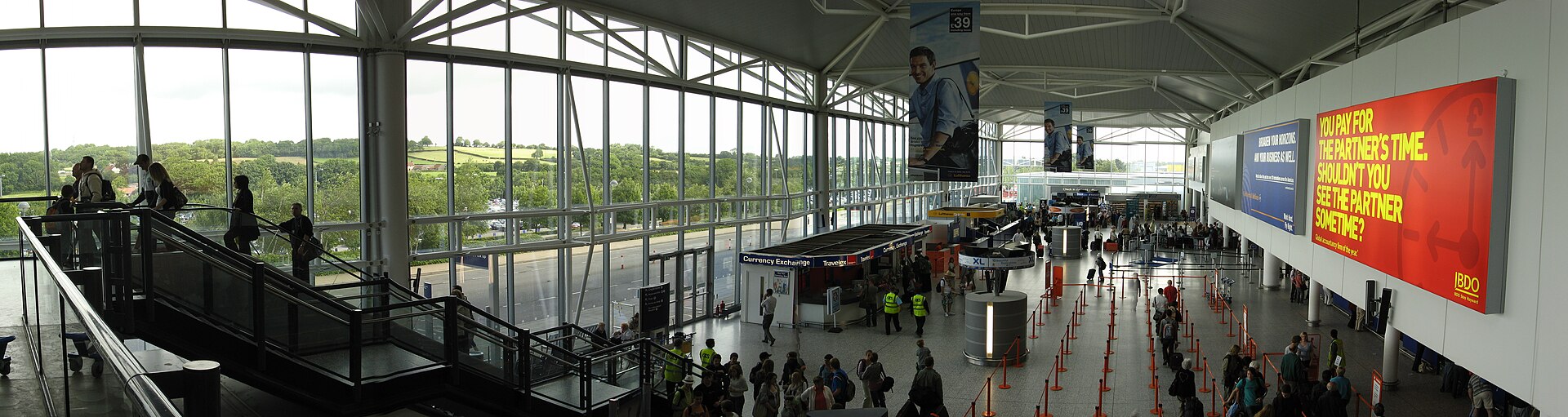 Bristol Airport's terminal departure hall, with passengers queuing through the check-in and security area.