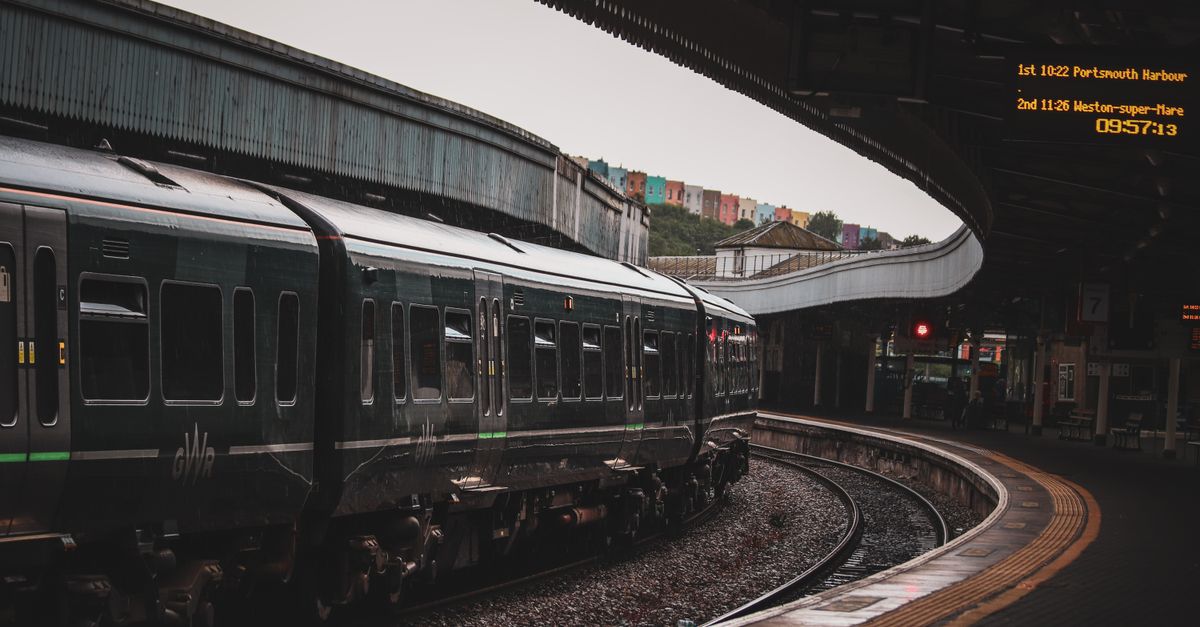 A GWR train arriving at a station platform with a departure board showing Weston-super-Mare