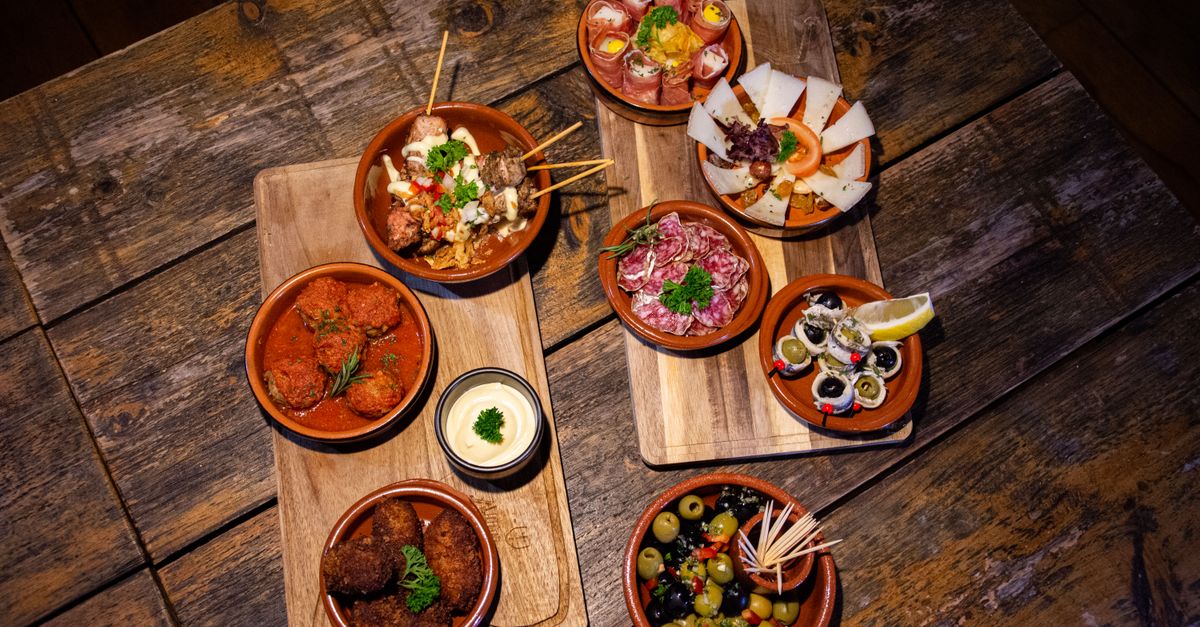Small shared plates of food arranged on a wooden restaurant table