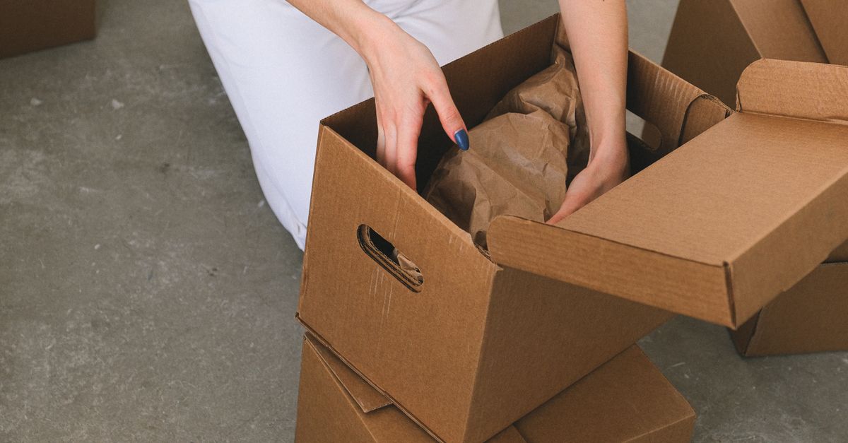 Hands unpacking a cardboard moving box