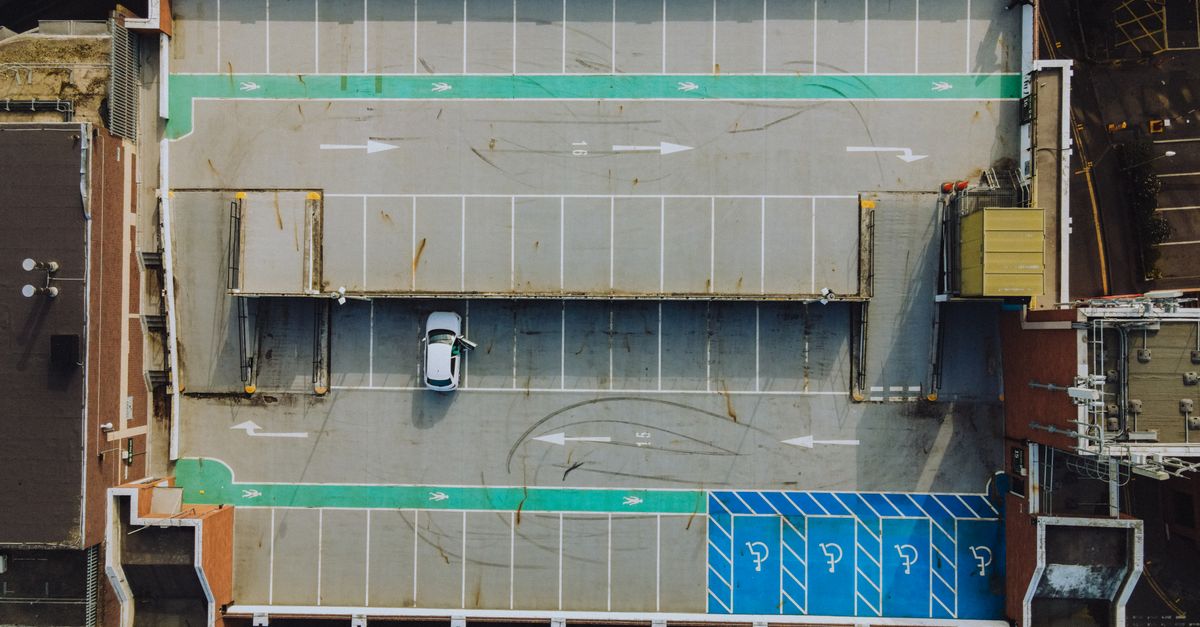 An aerial view of a car park with numbered general parking bays and a single parked car.